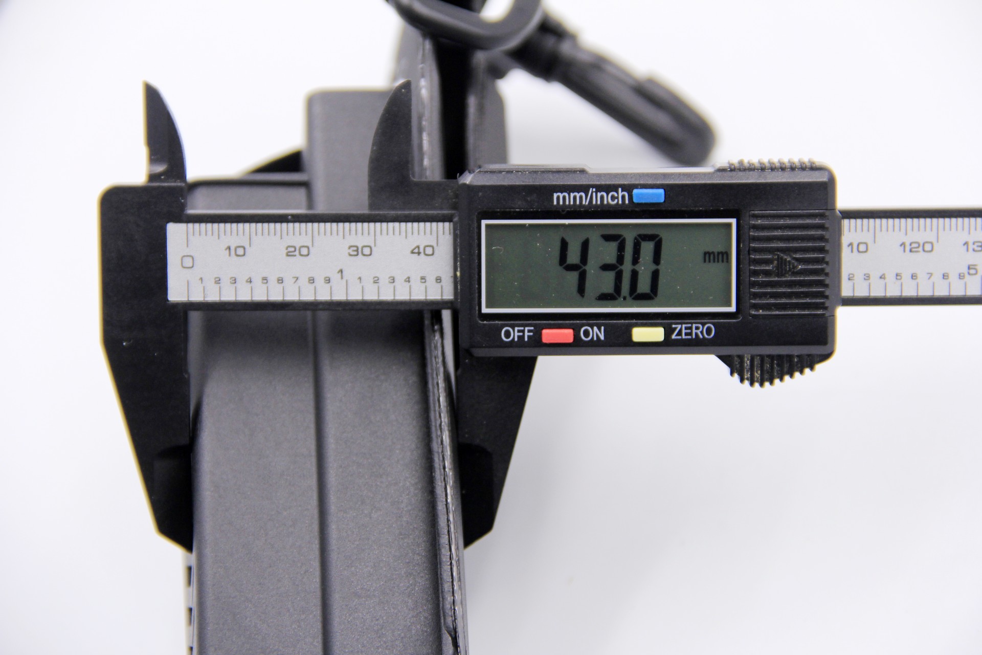 Digital caliper measuring the thickness of a WEFOX EVA Plier Pouch at 43.0mm, showing the slim profile of the black hard-shell EVA case from a side-on view with the attached carabiner clip visible at the top.