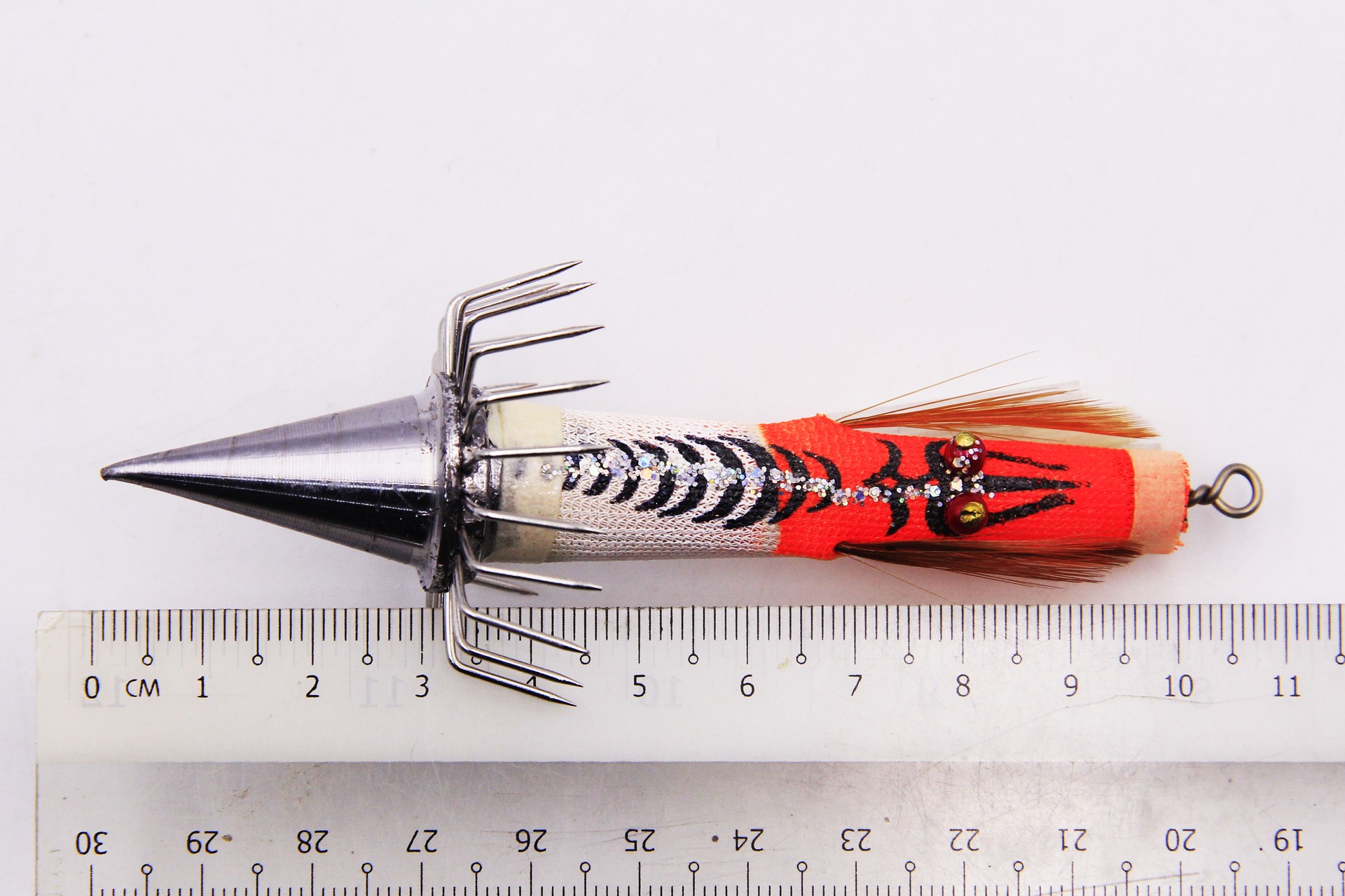 Bocean Candat Twist 80g Squid Jig Bottom Sinker with silver cone sinker, luminous zebra body, red feathers, umbrella hook beside 10cm ruler.