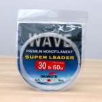 Okamoto Wave Super Soft Leader 30lb 0.60mm 60m premium monofilament leader line in clear hanging package on wood table.