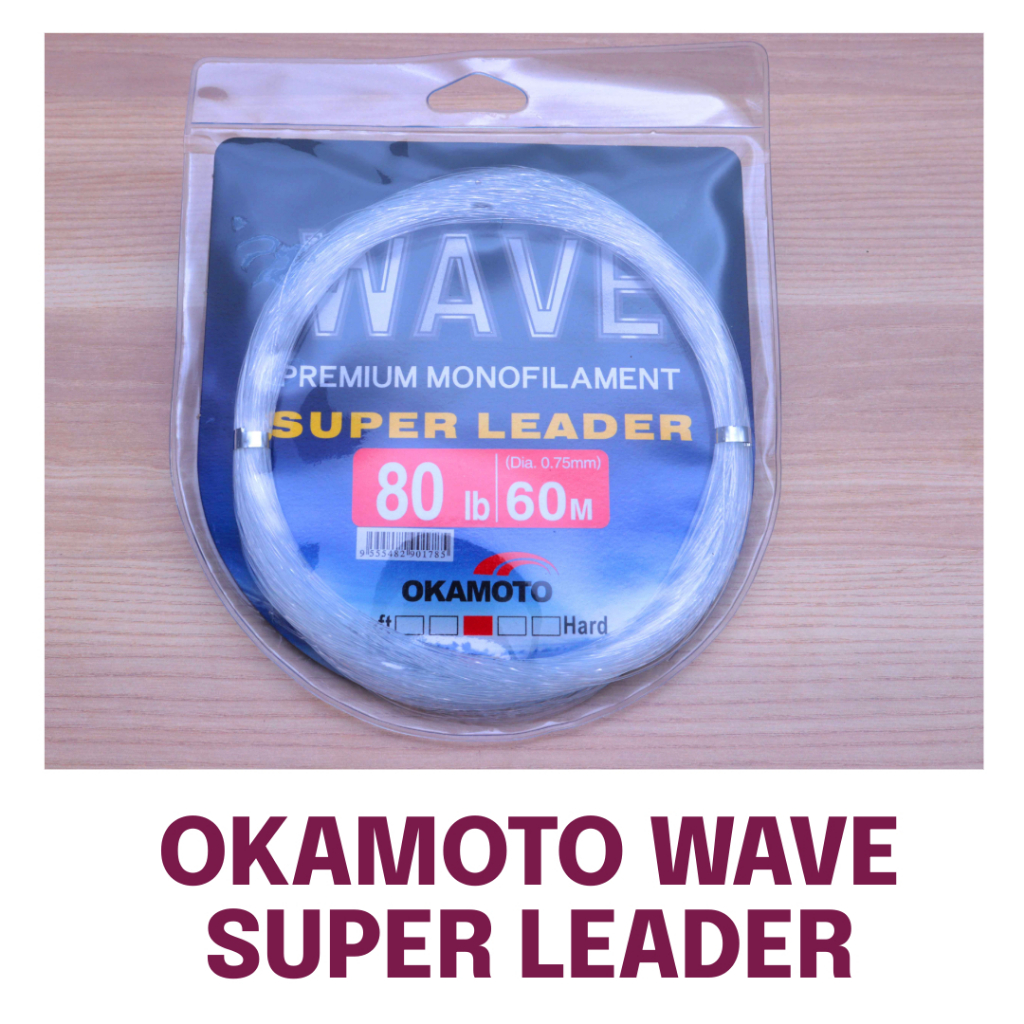 Okamoto Wave Super Soft Leader 80lb 60m premium monofilament coiled in clear blister pack on wooden table.