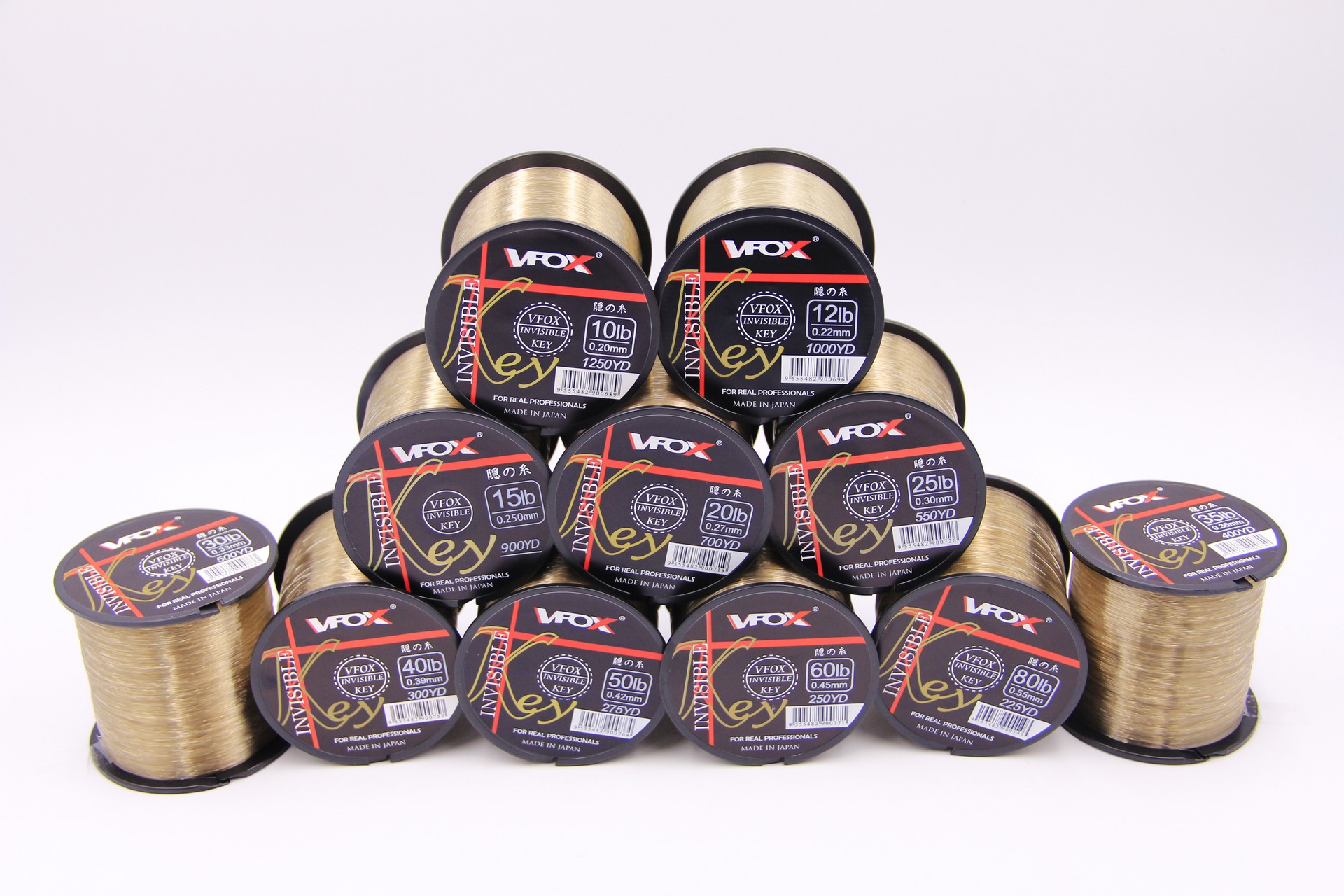 Stack of VFOX Invisible Key Fishing Line spools in 10lb-50lb strengths, showcasing light old gold fluorocarbon-coated line